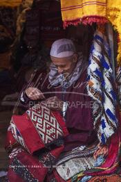 Image du Maroc Professionnelle de  Mohamed Chantaite Tisserand âgé de Soixante-seize ans, pose pour la photographie dans sa boutique de tapis et Kilim au Souk Tahti situé plus bas du Souk Semmarine, Monsieur Chantaite est ravis des ces photos dont il en parle avec une nostalgie comme jamais rencontré, d'ailleurs il m'avait montré plusieur de ses photos dont quelques parutions dans des journaux étrangers, le 15 Janvier 2008. (Photo / Abdeljalil Bounhar)

